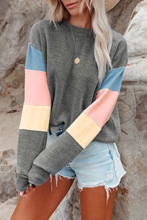 Gray sweatshirt with colorblock sleeves in French blue, dusty pink, and yellow.