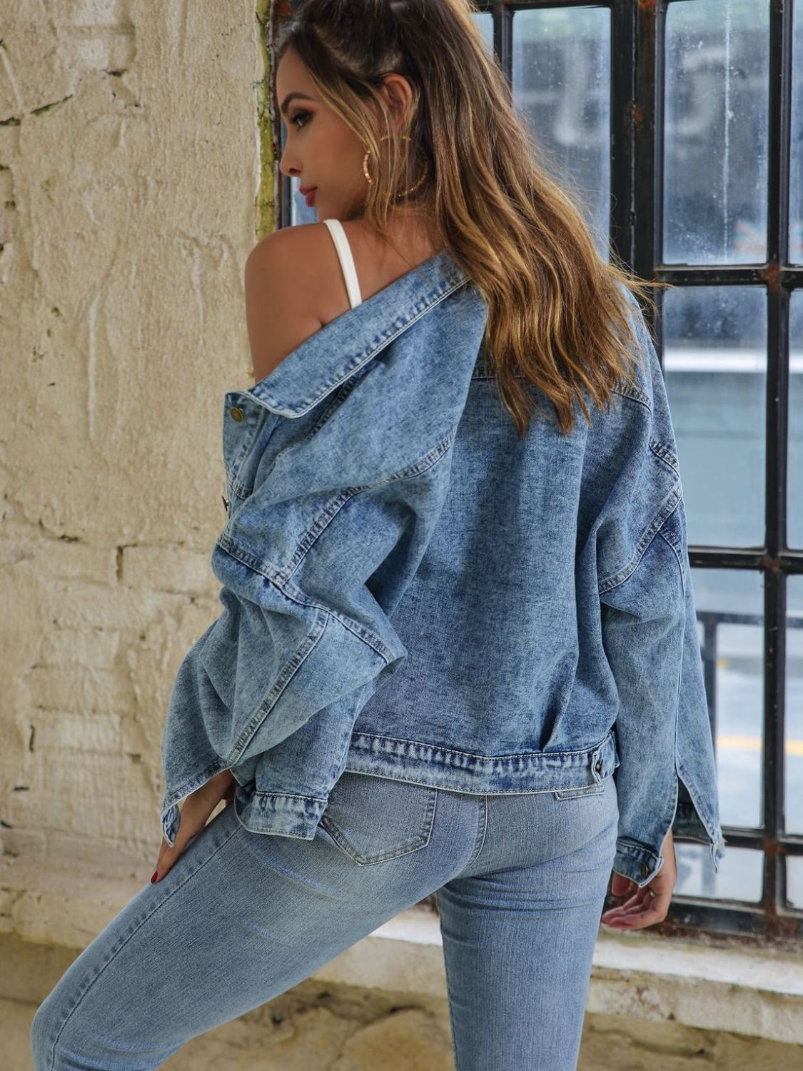 Light wash oversized denim jacket with buttoned patch pockets, worn open.