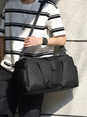 Black Oxford cloth travel bag with double handles and a detachable shoulder strap.