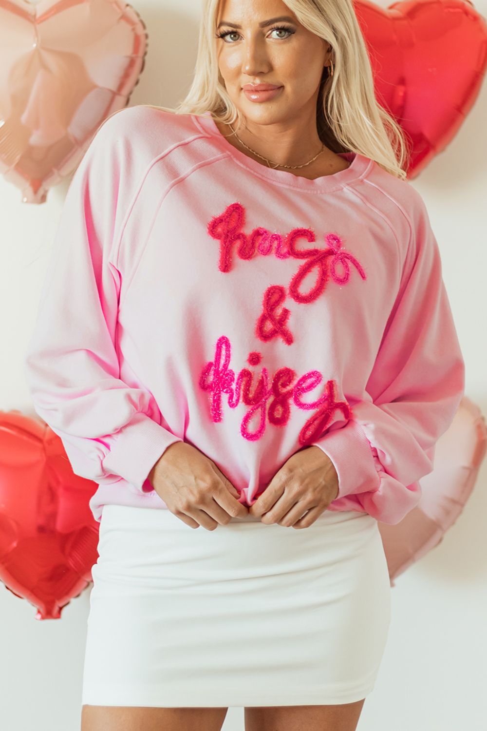 Blush pink sweatshirt with fuzzy "hugs & kisses" graphic, crew neck, long sleeves.