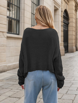 Black acrylic cable knit cocoon sweater with a wide neckline and relaxed fit.