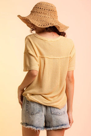 Yellow waffle knit V-neck top with short sleeves and a relaxed fit.