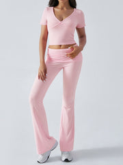 Blush pink ruched waistband flared lounge pants and a matching ruched V-neck crop top.