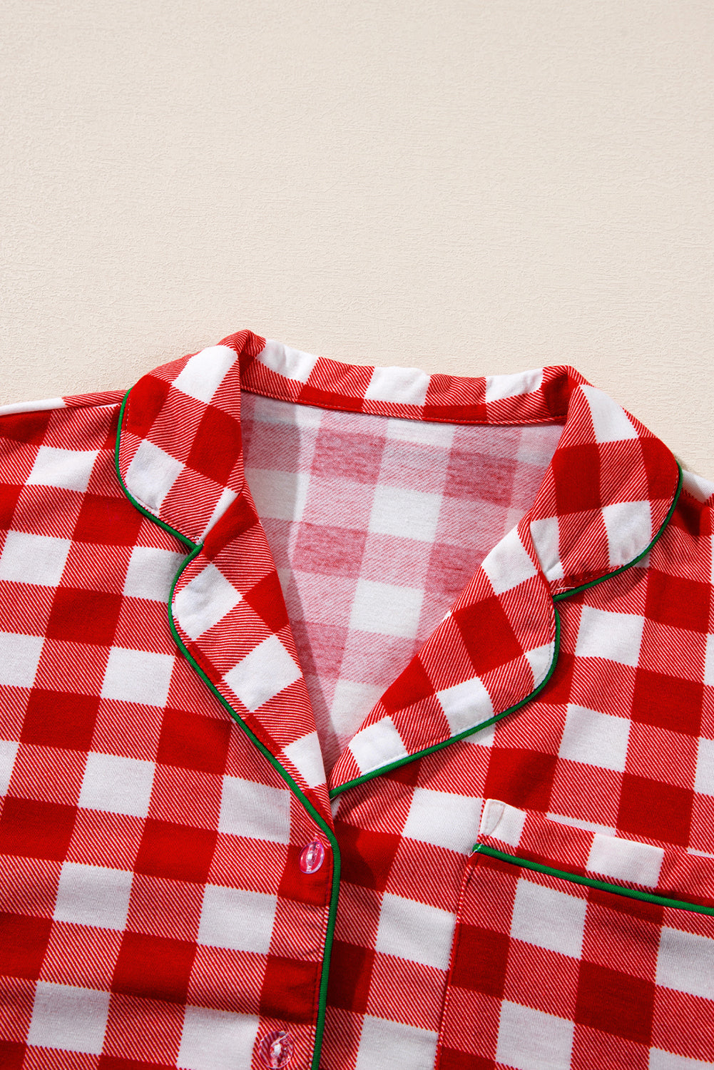 Festive red gingham pajama set with green trim and collared neckline.