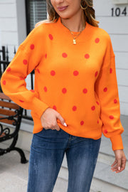 Orange polka dot knit sweater with balloon sleeves and mock neck.