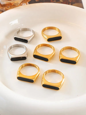 Rectangular enamel signet rings in gold and silver with black inlay.