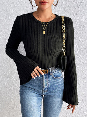 Black ribbed sweater with flared sleeves and crew neck, styled with jeans.