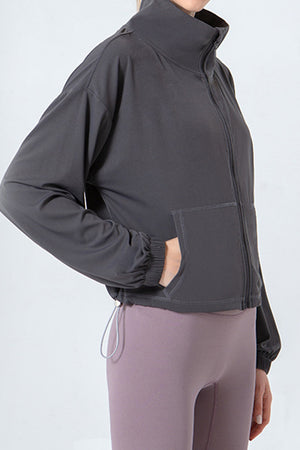 Dark gray active jacket with gathered hemline, zip front, and pockets.
