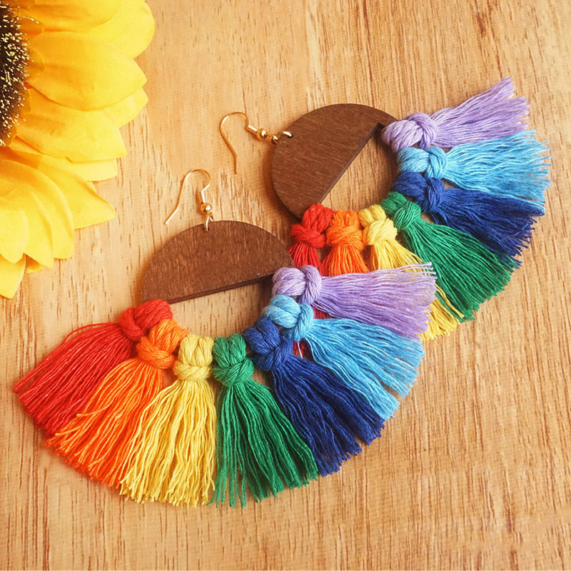 Rainbow fan tassel earrings with wooden half-circle detail.