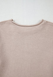 Beige knit sweater with a crew neck and visible panel sleeve detail.
