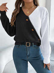 Asymmetrical black and white colorblock knit sweater with button detail.