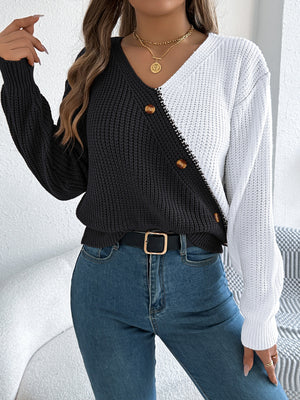Asymmetrical black and white colorblock knit sweater with button detail.