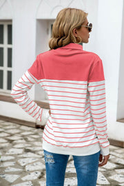 Colorblock stripe turtleneck knit sweater with coral and white stripes.