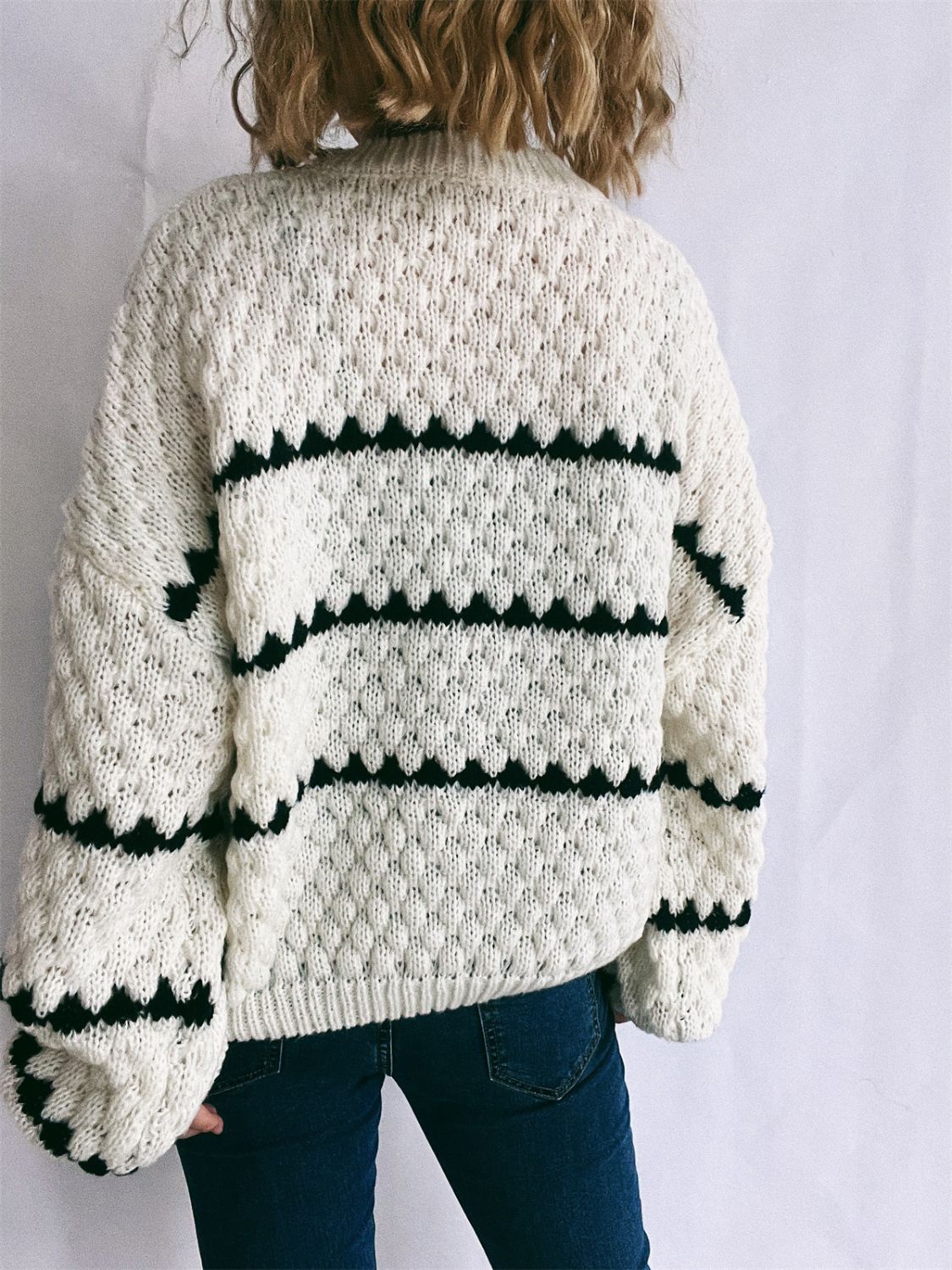 White knit jumper with textured chevron stripes and black detailing.