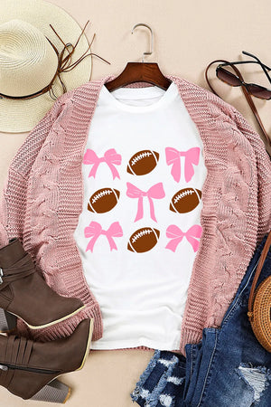 White graphic tee with a pattern of pink bows and brown footballs.