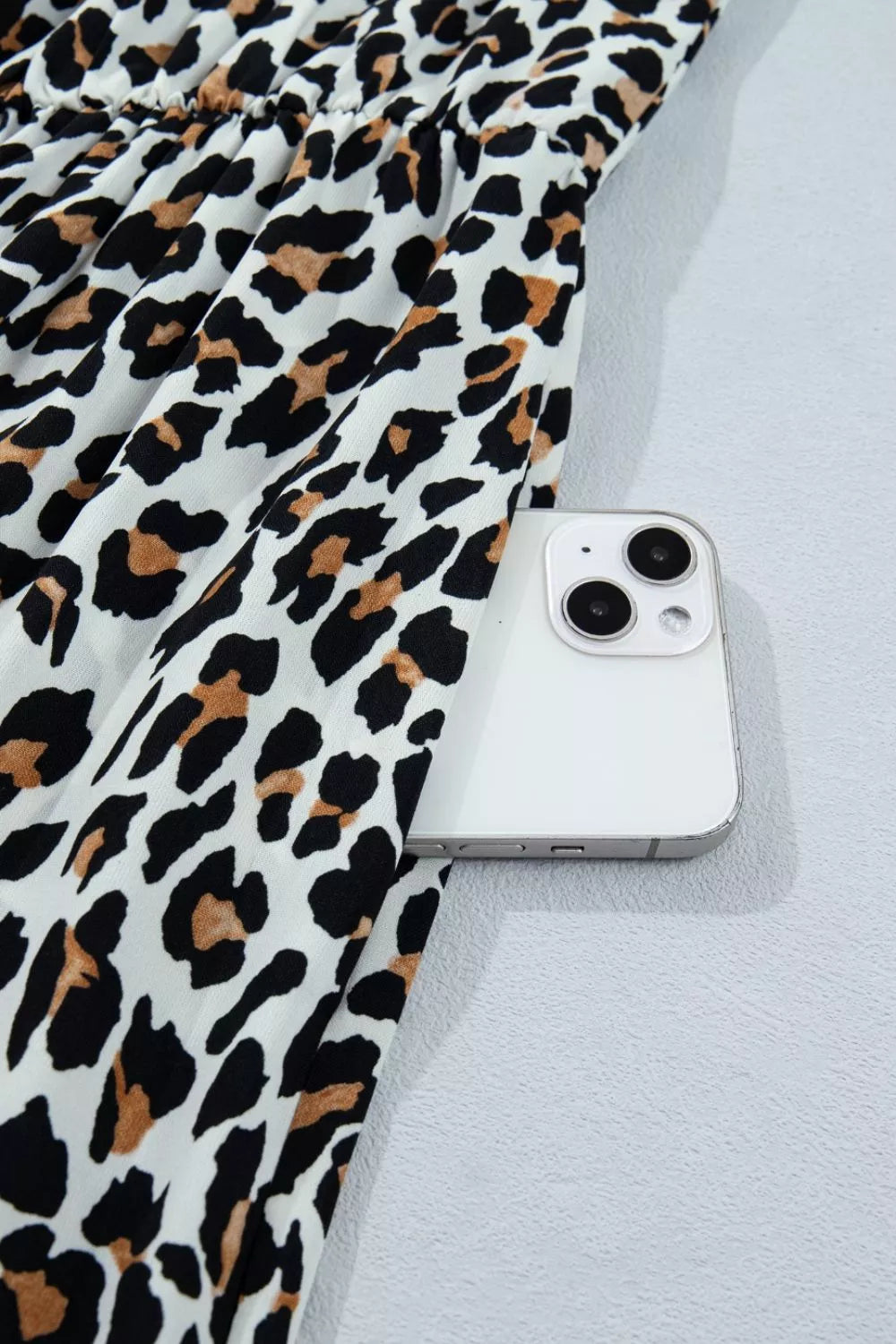 Leopard print midi dress with cinched waist detail and side pocket for a phone.