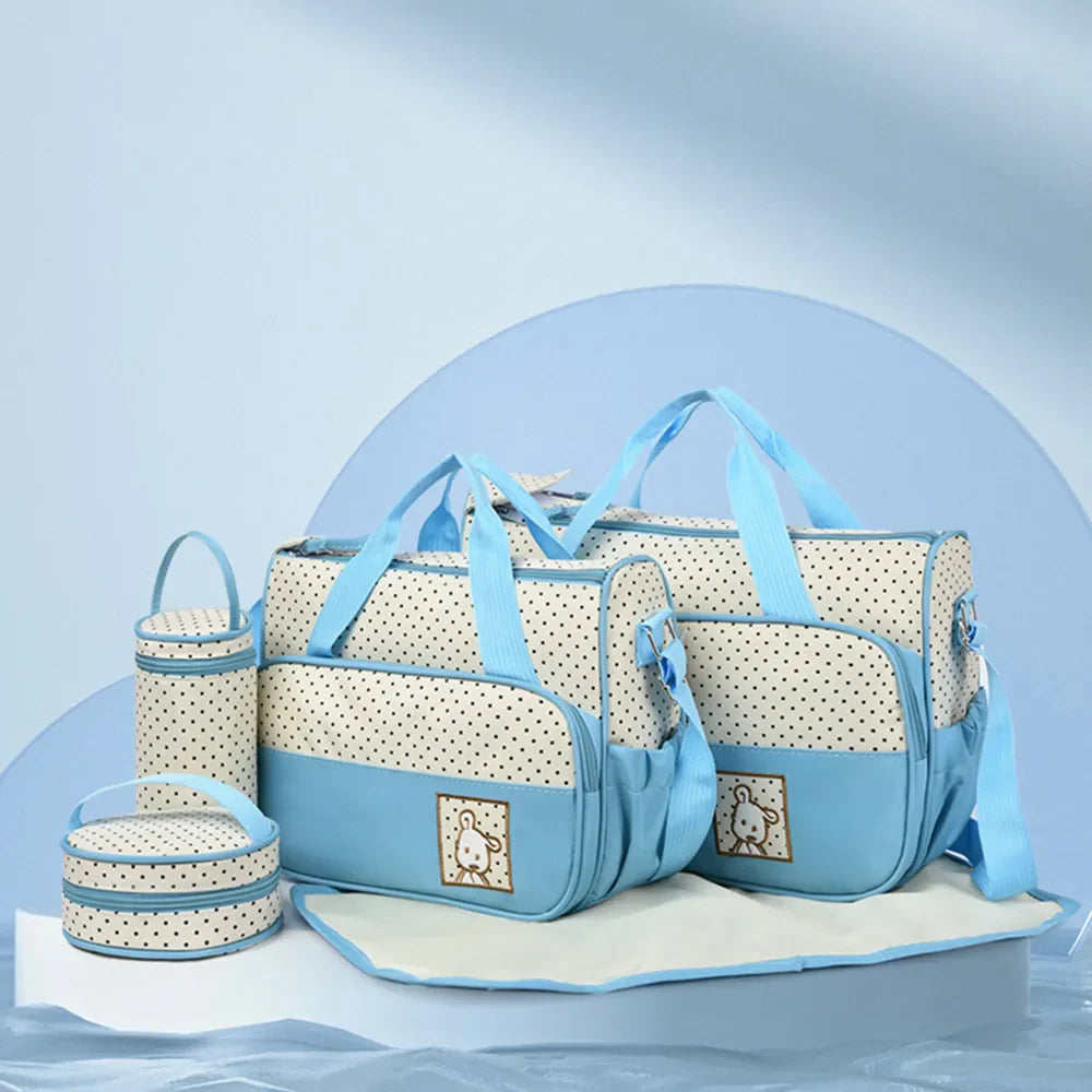 Polka dot diaper bag set in pastel blue with matching accessories and embroidered bunny detail.