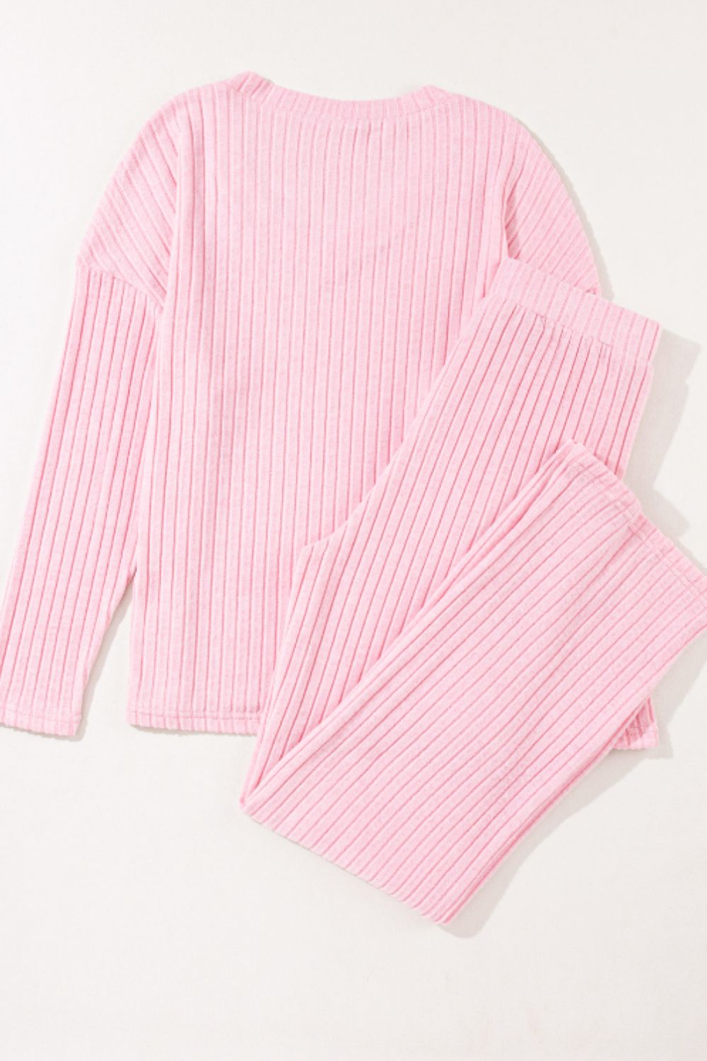 Blush pink ribbed V-neck loungewear set with long sleeves and matching pants.