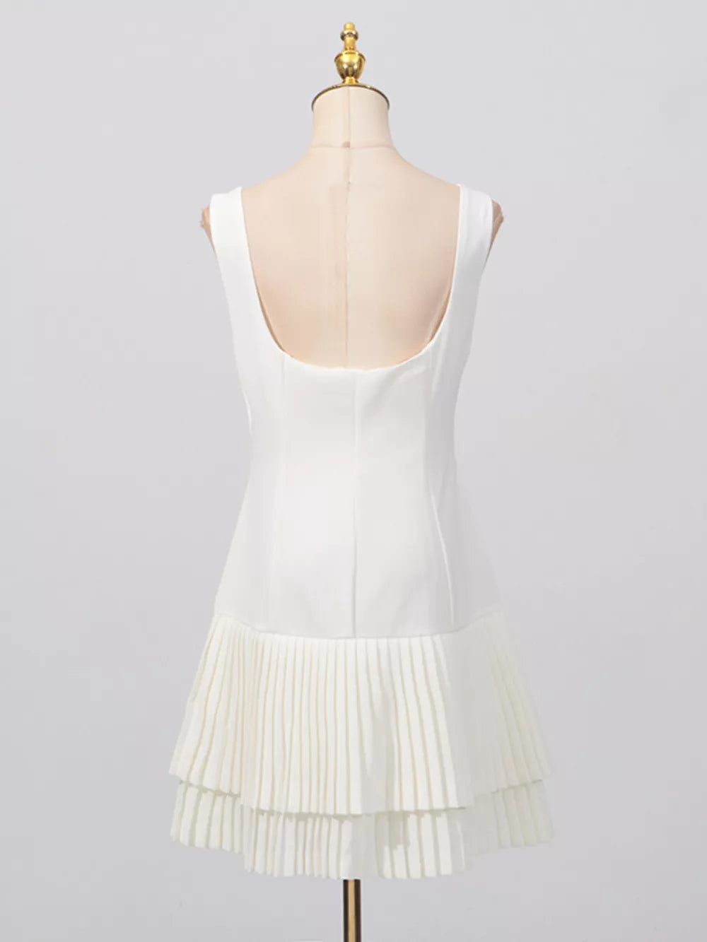 White mini dress with square neck and pleated tiered hem
