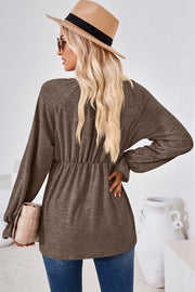 Mocha knit blouse with cinched waist, long balloon sleeves, and ruffled cuffs.