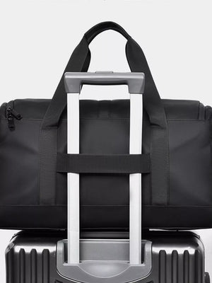 Black Oxford cloth travel bag with top handles and a luggage strap detail.