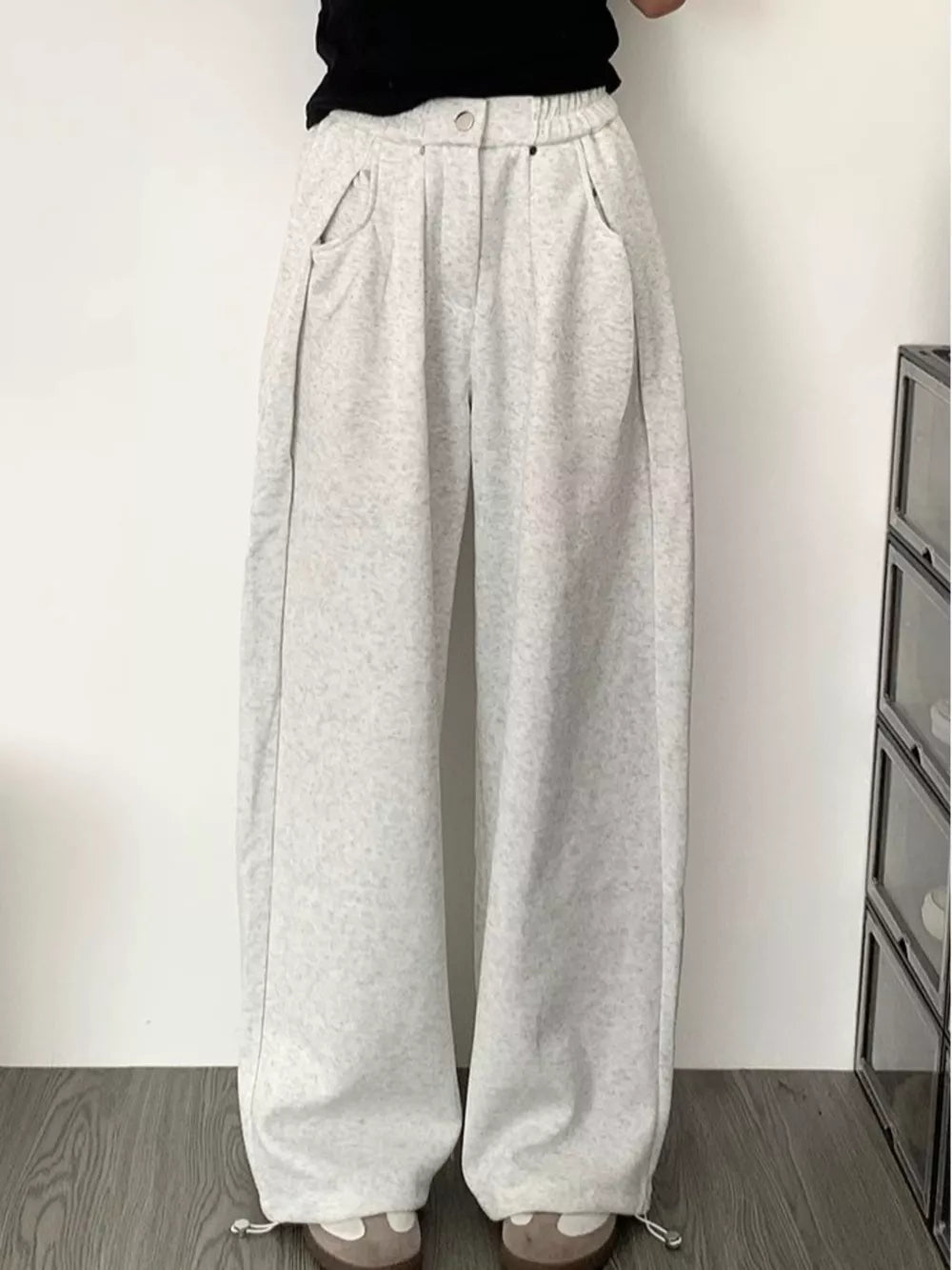 Men's gray wide-leg sweatpants with adjustable drawstring hem and pockets.