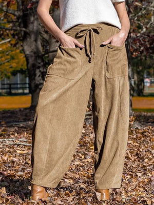 Brown corduroy wide-leg pants with drawstring waist and large front pockets.