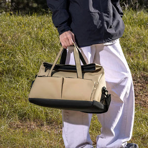 Khaki nylon travel duffel bag with multiple exterior pockets and black accents.