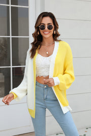 Colorblock knit cardigan with contrast trim in yellow and white, featuring balloon sleeves and a relaxed fit.