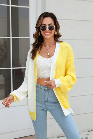 Colorblock knit cardigan with contrast trim in yellow and white, featuring balloon sleeves and a relaxed fit.