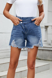 Dusty blue denim shorts with asymmetric waistline and distressed hem.