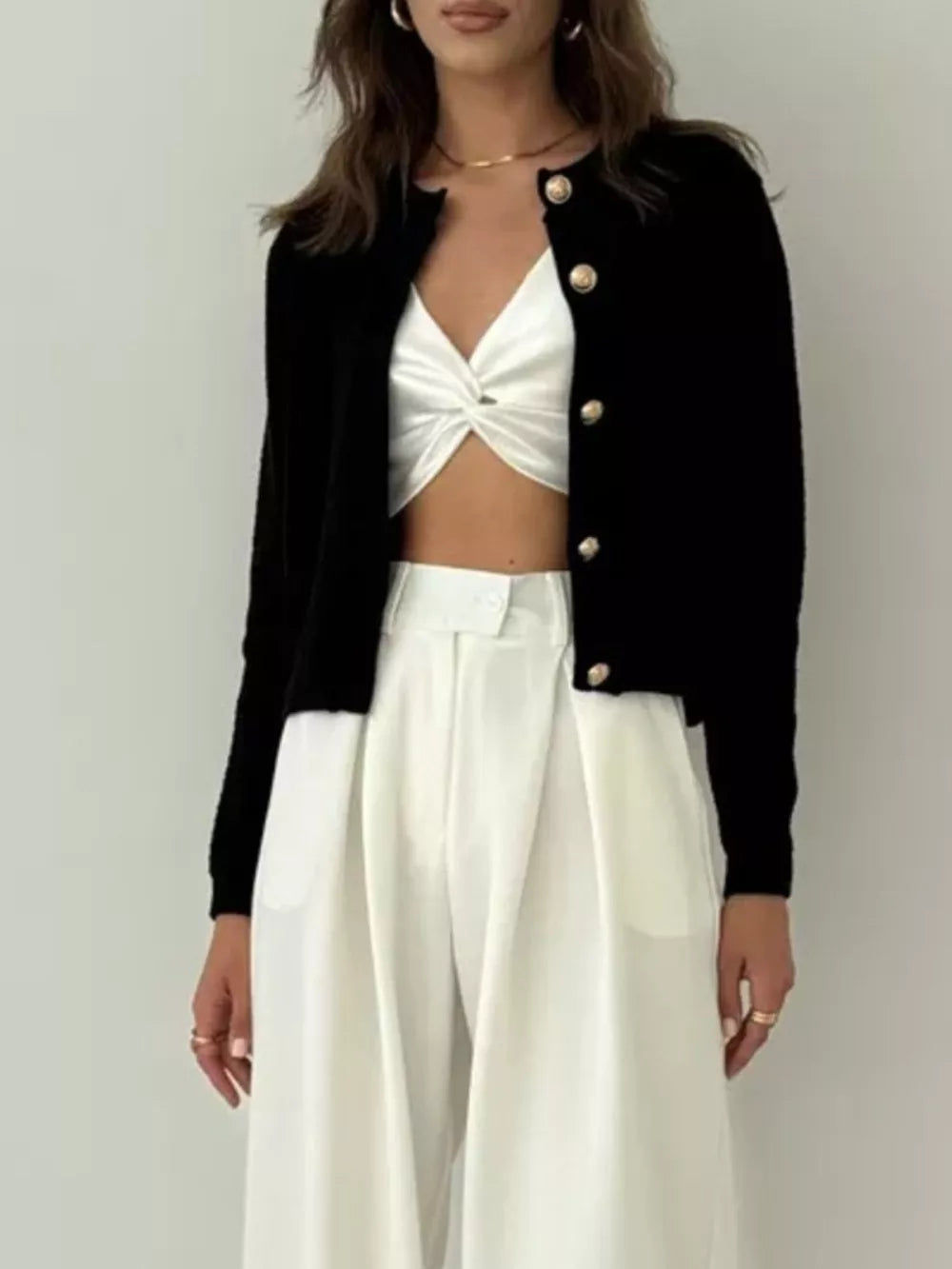 Black textured knit cardigan with gold button detail and crew neck.