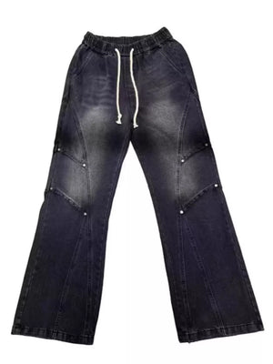 Distressed black wide-leg jeans for men with drawstring waist and studded panel details.