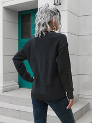 Black acrylic knit sweater with button detail and crew neck, casual style.