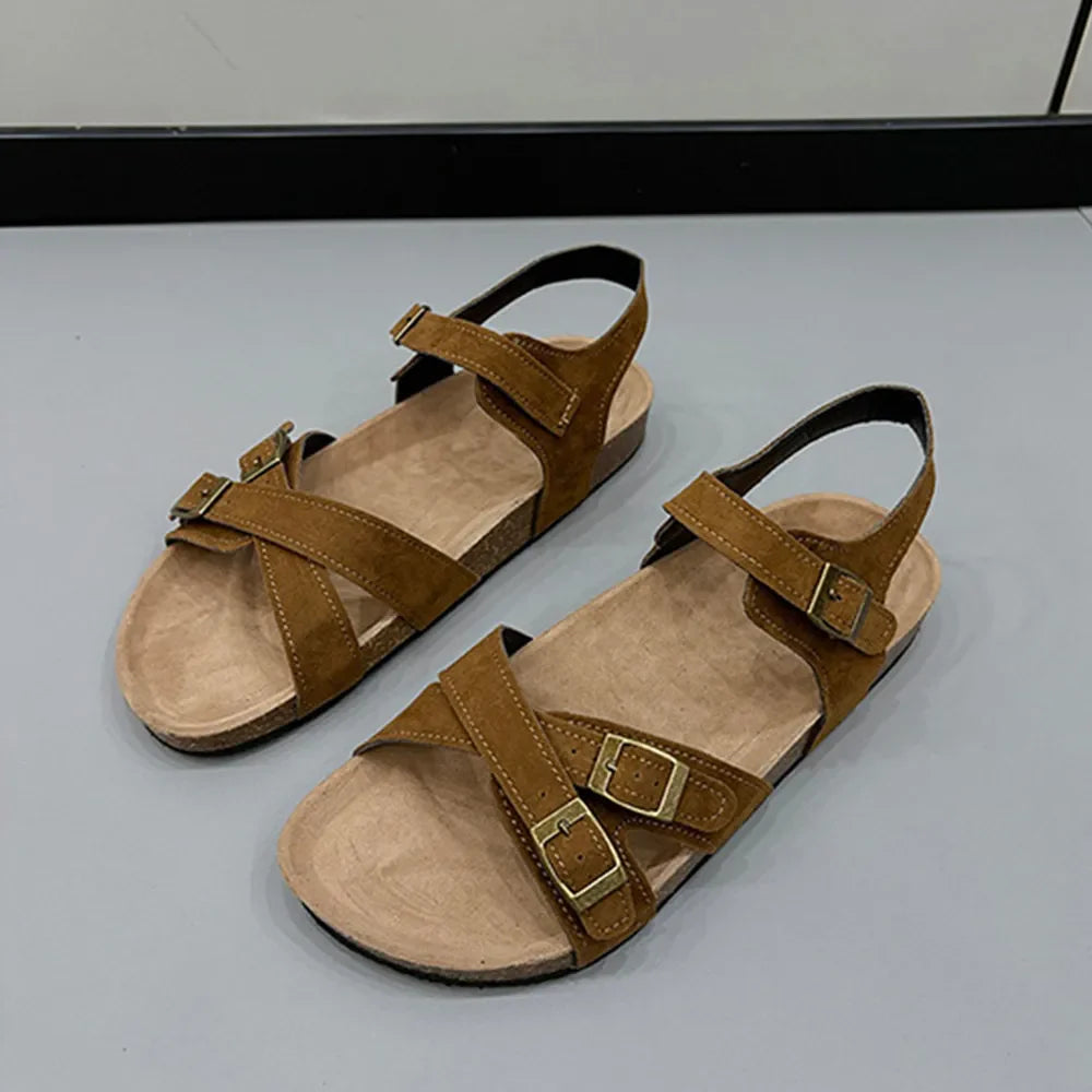 Suede crossover buckle cork sandals in mocha with adjustable straps and gold buckles.