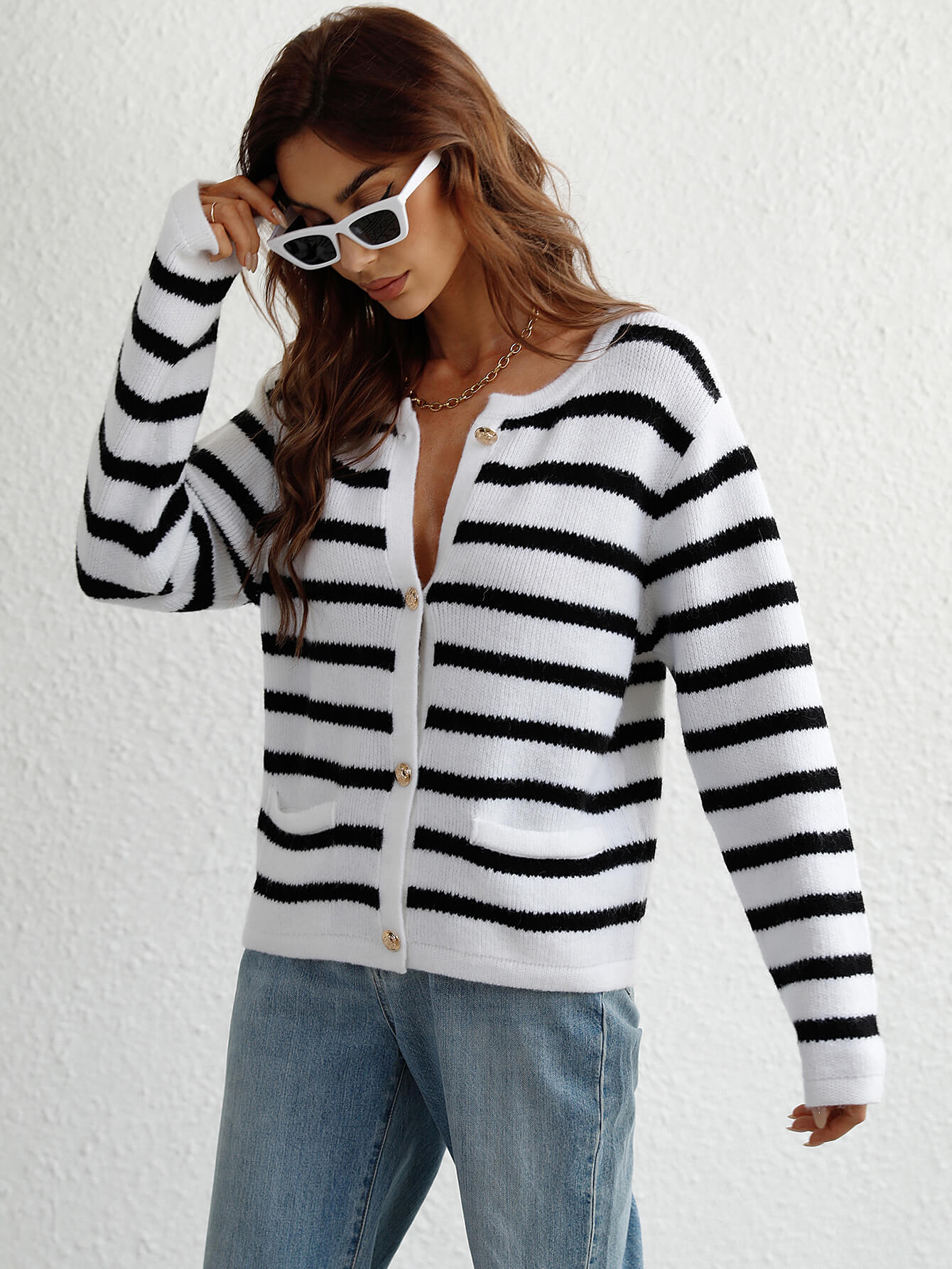 White and black horizontal stripe knit cardigan with pockets and button front.