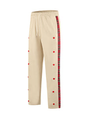 Khaki sweatpants with red dot embroidery and plaid side trim.