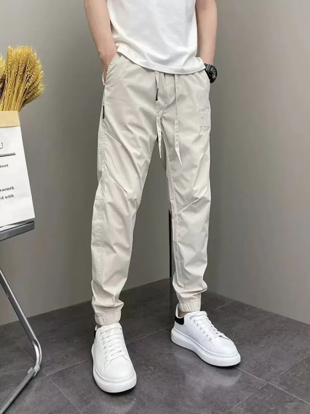 Men's beige cotton drawstring sweatpants with cuffed ankles.