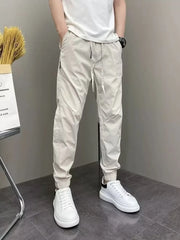 Men's beige cotton drawstring sweatpants with cuffed ankles.
