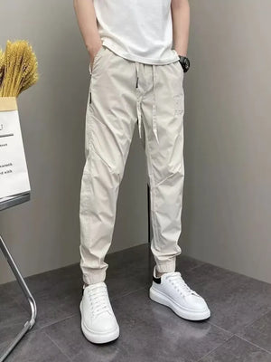 Men's beige cotton drawstring sweatpants with cuffed ankles.