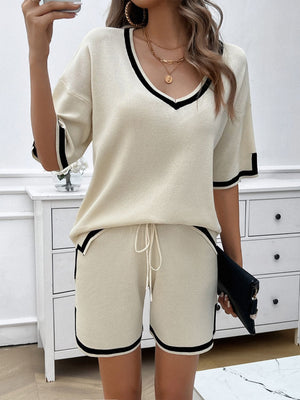 Cream knit loungewear set with black contrast trim, V-neck top, and drawstring shorts.