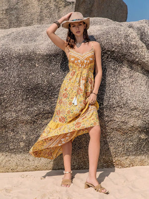 Yellow floral print cami dress with tiered hem and tassel detail.