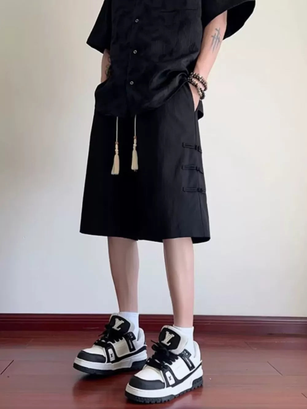 Black chino shorts with drawstring and toggle details, mid-length.