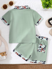 Sage green baby polo and shorts set with camouflage collar and trim.