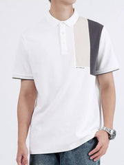 White cotton polo shirt with asymmetrical color-block detail on the chest and dark trim on sleeves.