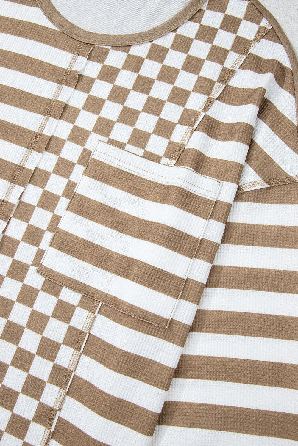 Camel and white checkered and striped knit top with a chest pocket.