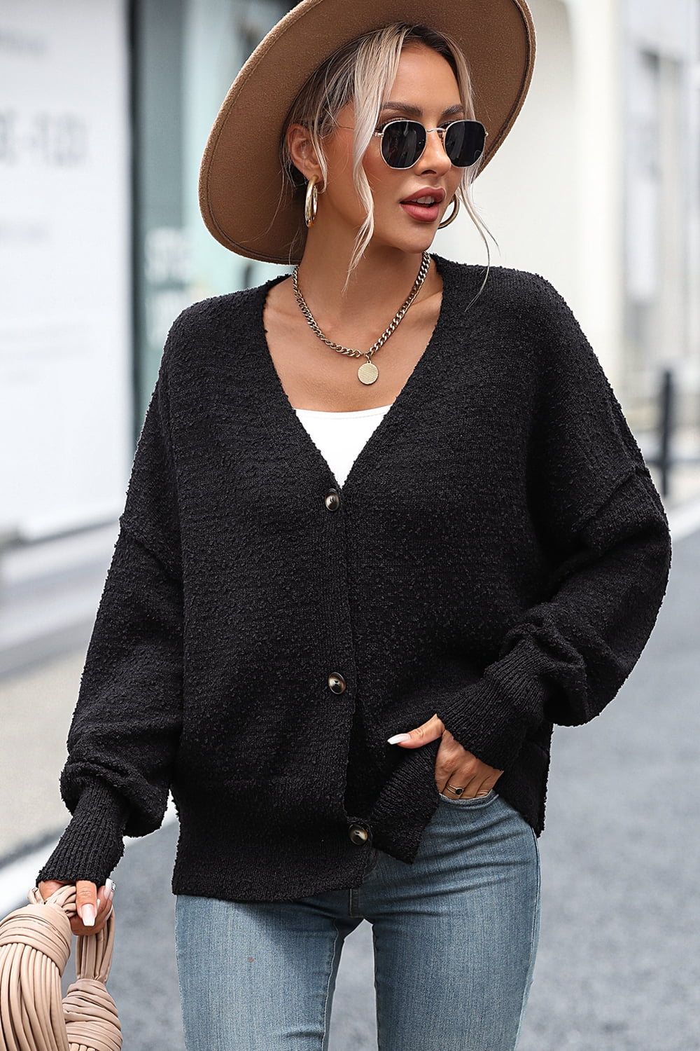 Black textured bouclé button-down cardigan with V-neck and long sleeves.
