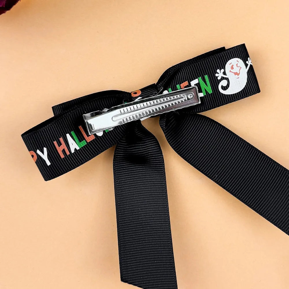 Black Halloween print bow hair clip with ghost and text, silver metal clip.