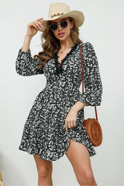 Black floral print mini dress with lace trim neckline and bell sleeves.