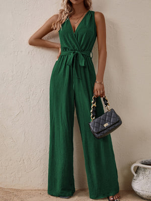 Dark green textured wrap-front wide-leg jumpsuit with tie waist and V-neck.